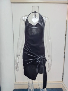 Detail of black halter sleeveless dress with metallic waist knot and asymmetric hem