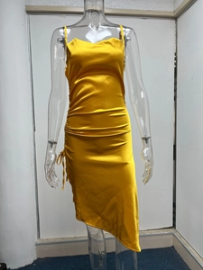 Détail de la robe en satin jaune avec fronces latérales et ourlet asymétrique stylé