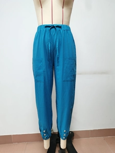 Dettaglio dei pantaloni cargo blu vivace con vita elastica a coulisse e tasche laterali