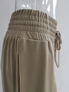 Dettaglio dell'elastico in vita e della coulisse sui pantaloni beige a gamba larga