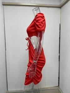 Dettaglio dell'abito in maglia a costine rosse con cut-out laterali e lacci