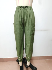 Dettaglio dei pantaloni in cotone e lino verde oliva con risvolti bottoni e tasche