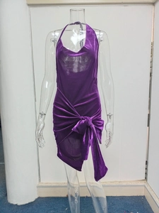Detail of purple velvet halter dress with oversized bow tie and asymmetrical hem