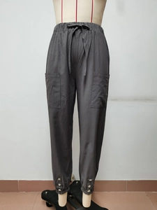 Dettaglio dei pantaloni in cotone e lino grigio scuro con tasche e bottoni sul fondo