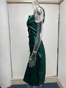 Détail de la robe en satin vert émeraude avec des fronces latérales et un tissu soyeux