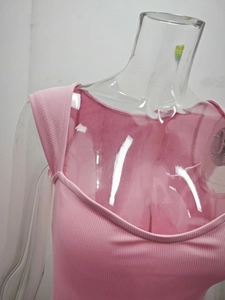 Dettaglio della texture in maglia a coste rosa su miniabito senza maniche con scollo a U