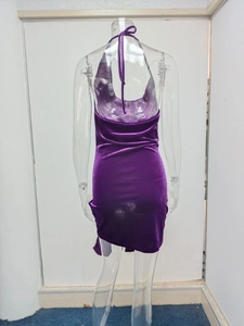 Detail of purple velvet halter neck dress featuring open back and side slit design