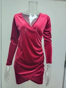 Detail of burgundy velvet V-neck dress featuring cross-wrap asymmetric hem and soft texture