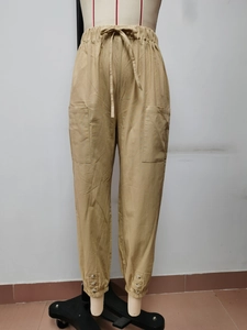 Dettaglio dei pantaloni in lino kaki con vita elastica e grandi tasche applicate laterali