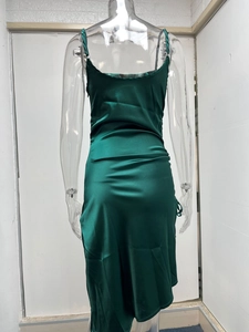 Détail du dos d'une robe en satin vert foncé ajustée avec une texture soyeuse