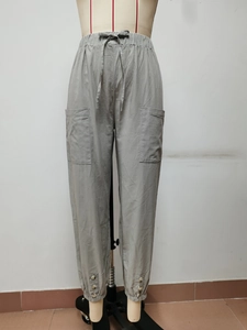 Dettaglio dei pantaloni in cotone e lino con vita elastica e bottoni sul fondo gamba