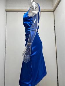 Détail d'une robe mi-longue en satin bleu roi avec fente latérale et fronces élégantes