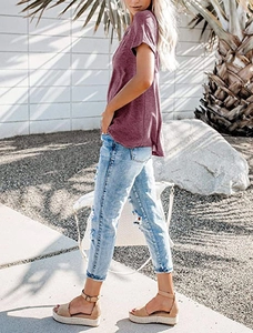 Side view of woman wearing deep purple V-neck short sleeve T-shirt with denim jeans