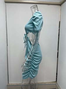 Dettaglio dell'abito in maglia azzurro con ritaglio laterale e lacci regolabili
