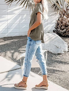 Outdoor shot of olive green V-neck T-shirt paired with distressed light blue jeans