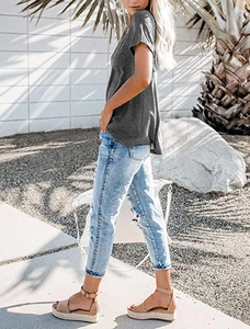 Close-up of a women's V-neck gray T-shirt paired with distressed jeans and wedge sandals