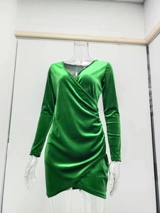 Detail of emerald green V-neck velvet dress featuring ruched sides and asymmetric hemline