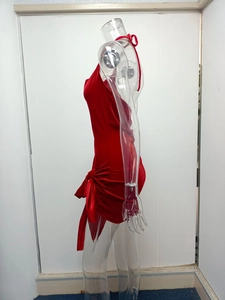 Detail of red velvet halter dress featuring side tie-up bows and asymmetric split hem