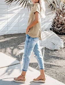 Outdoor shot of a women's V-neck khaki t-shirt paired with ripped jeans and sandals