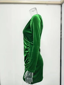 Detailed side view of dark green ruched velvet dress showing texture and fabric sheen