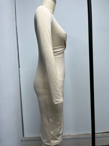 Dettaglio del design intrecciato in vita e della texture pieghettata su questo abito