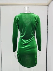 Close-up of the back view of a green velvet V-neck long sleeve dress with textured fabric
