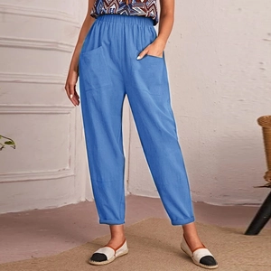 Detail of blue cotton linen trousers showing elastic waist and large patch pockets