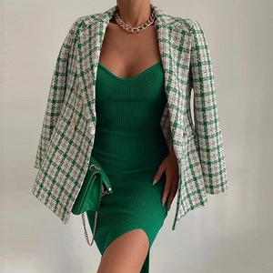 Détail de la robe en maille vert foncé avec un blazer à carreaux et des boutons dorés