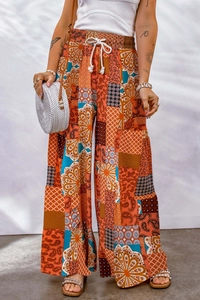 Detail of high-waist boho floral wide-leg trousers with drawstring and paisley patterns