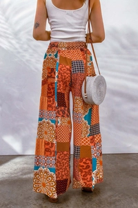 Rear view of high-waisted bohemian wide-leg pants with vibrant floral paisley patchwork