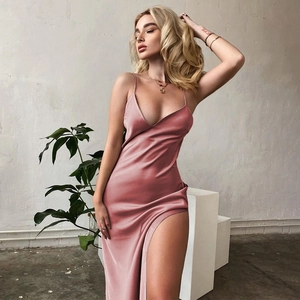 Detailed close-up of pink satin dress fabric with high slit and elegant draped hemline