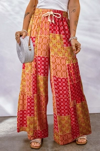 Detail of high waisted floral wide leg trousers with colorful patterns and drawstring tie