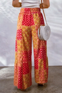 Detail of high-waist floral wide-leg trousers with bohemian patchwork patterns