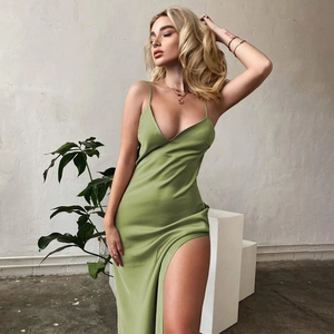 Detail of elegant grass green satin dress featuring a high side slit and smooth texture