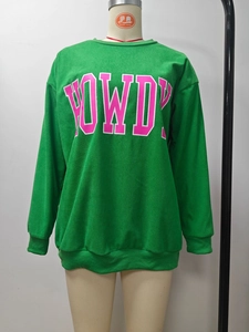 Détail du sweat-shirt vert avec imprimé de lettres Howdy en rose et blanc cassé