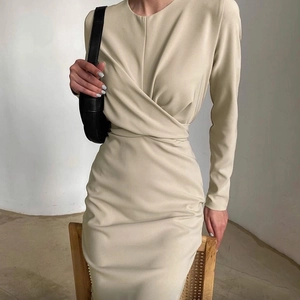 Dettaglio elegante abito a portafoglio beige con scollo a incrocio e pieghe in vita