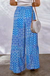 Detail of bohemian high-waisted wide-leg trousers with blue floral and geometric patterns