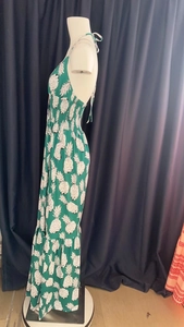 Side view of tiered green halter dress with white pineapple print and smocked waist detail