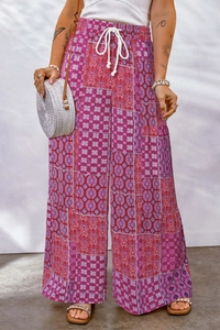 Detail of high-waist floral wide-leg pants featuring pink geometric patterns and white drawstring