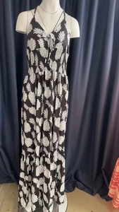 Detail view of high-waist smocking and white pineapple print on a black halter maxi dress