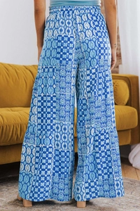 Detail of high-waisted bohemian wide-leg trousers with blue floral patchwork patterns