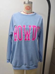 Détail d'un sweat bleu clair à manches longues côtelé avec imprimé rose Howdy