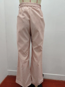 Detail view of high waist elastic waistband and pink fabric on casual wide leg trousers