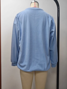 Détail du sweat à rayures bleu clair montrant la texture douce et les coutures d'épaule