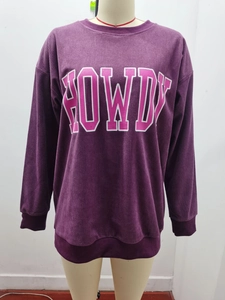 Détail du sweat en velours côtelé violet avec imprimé Howdy rose et poignets côtelés