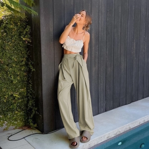 Detail of high-waisted wide leg pants with side tie waist and pleated cropped top