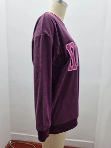 Détail du sweat en velours côtelé violet montrant l'épaule tombante et l'imprimé