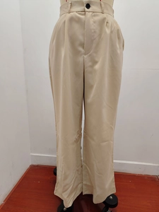 Detailed view of high waist beige wide leg trousers with black button and pleats