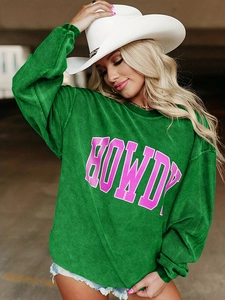 Détail du sweat en velours côtelé vert montrant le lettrage Howdy et la texture du tissu