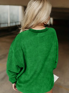 Détail d'un sweat-shirt vert vif oversize avec texture velours côtelé et épaules tombantes